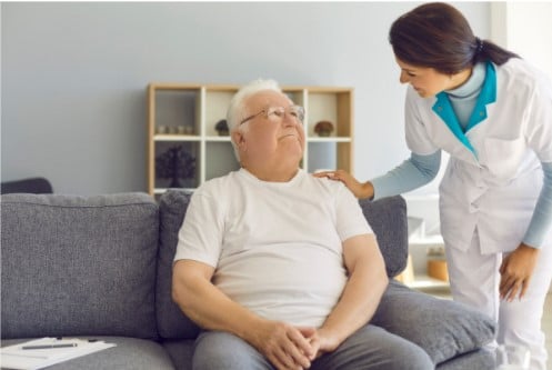 happy elderly man talking to nurse in nursing home